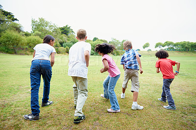 Buy stock photo Rearview shot of a group of children racing in a field