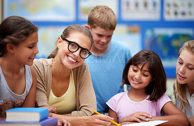Buy stock photo Happy teacher, students and writing for learning, education or tutoring in classroom at school. Woman, mentor or educator helping young kids or children with books for studying or literature in class