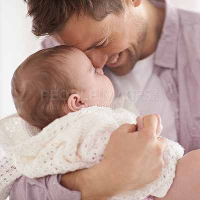 Buy stock photo Shot of a young father holding his adorable baby daughter and showing her affection