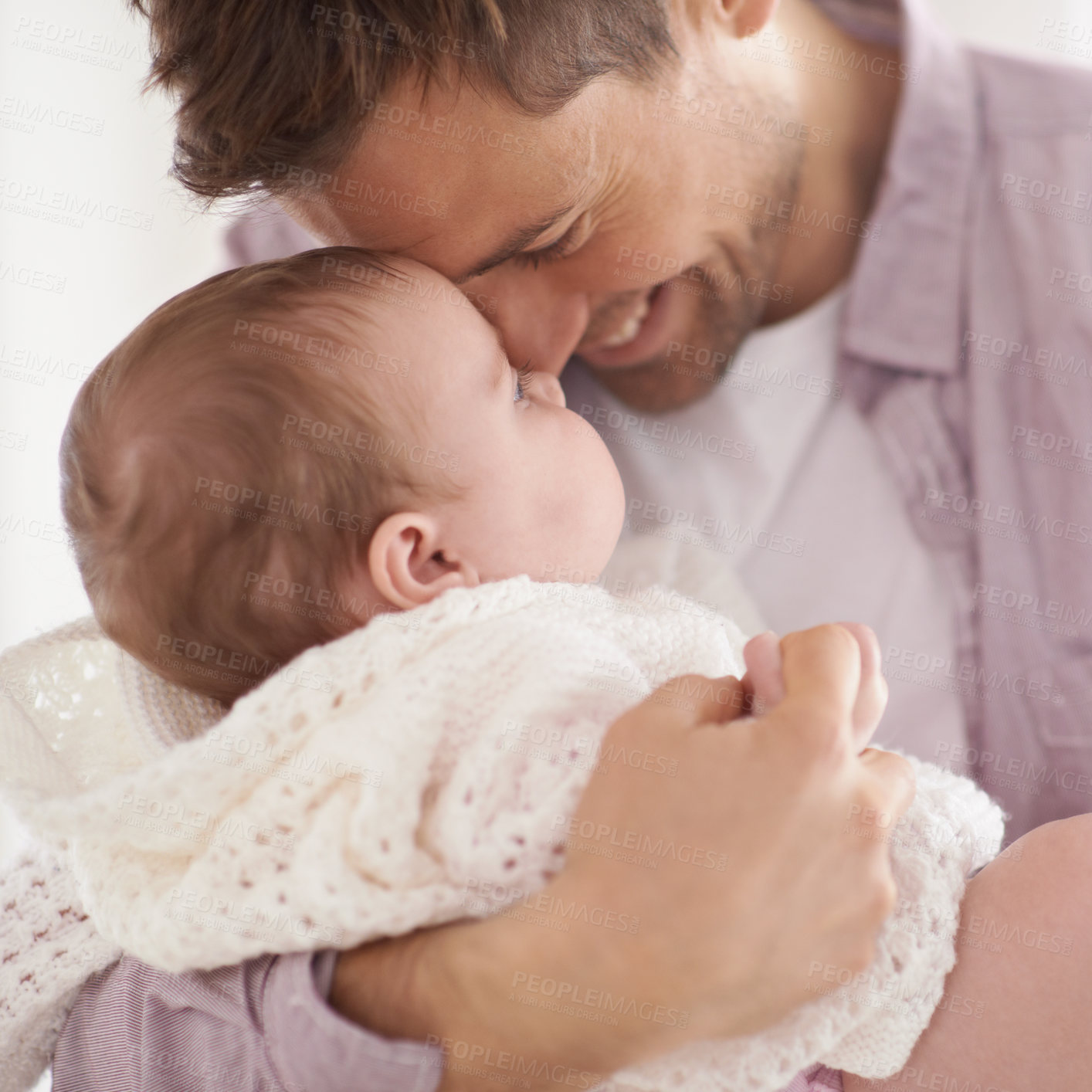 Buy stock photo Shot of a young father holding his adorable baby daughter and showing her affection