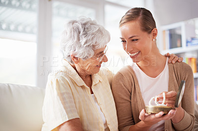 Buy stock photo Happy, necklace and senior mother with woman for gift, present and surprise in living room. Family, love and daughter with mom giving pearls on sofa for celebration, birthday and bonding in home