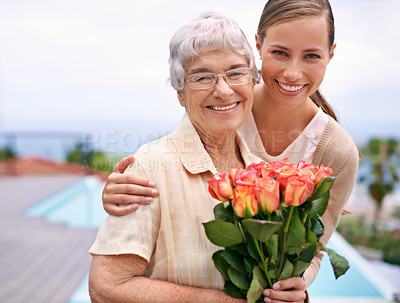 Buy stock photo Senior woman, daughter and portrait with flowers, hug and care for love, bonding and reunion at family home. People, elderly mom and mothers day celebration with connection, gift and smile in garden