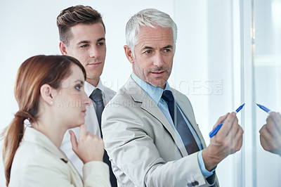 Buy stock photo Glass wall, writing and business people with teamwork, cooperation and brainstorming with financial growth. Thinking, group and manager with employees or teaching with collaboration and partnership