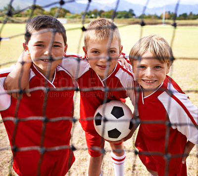 Buy stock photo Kids, soccer team and portrait with smile, goal net and boys with teamwork, support or solidarity. Energy, sports and friendship, together and happy for win, ready for game and physical activity