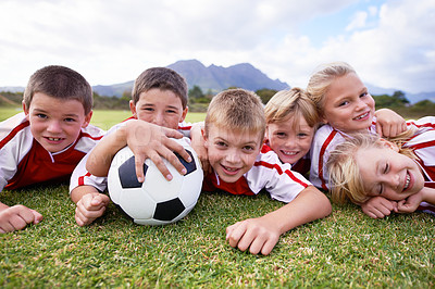 Buy stock photo Children, soccer ball and relax on green grass or field for outdoor match, game. or team sports. Group of kids, friends or football players smile lying together for competition on stadium in nature