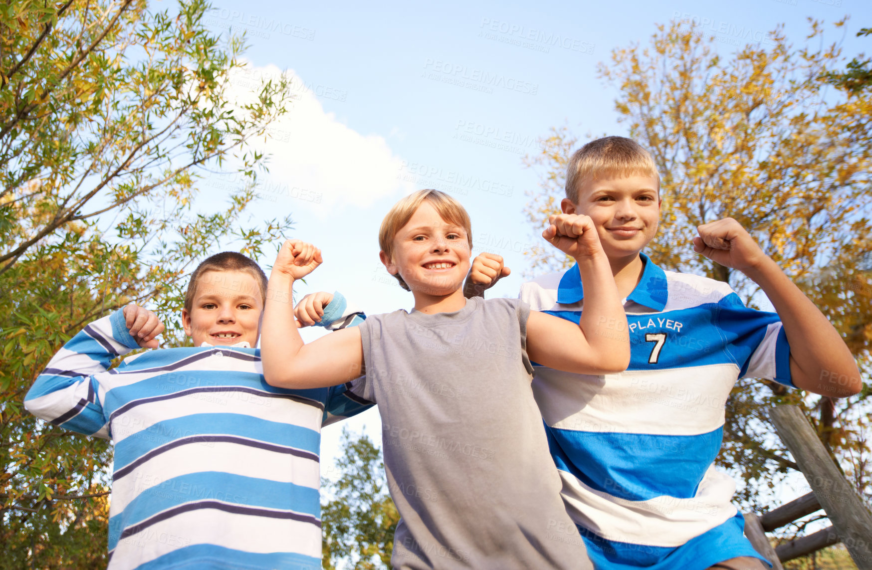 Buy stock photo Happy children, portrait and flexing muscles at park for fun day, holiday or weekend together in nature. Face of young kids or friends smile for outdoor summer break, bonding or youth on playground