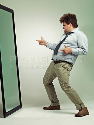 Buy stock photo Shot of an excited overweight man celebrating while looking in a mirror