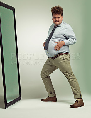 Buy stock photo Funny, portrait and man happy with mirror, plus size and overweight with hand on stomach or abdomen. Confident, male person and guy with double chin from fat in body, unique and crazy in studio