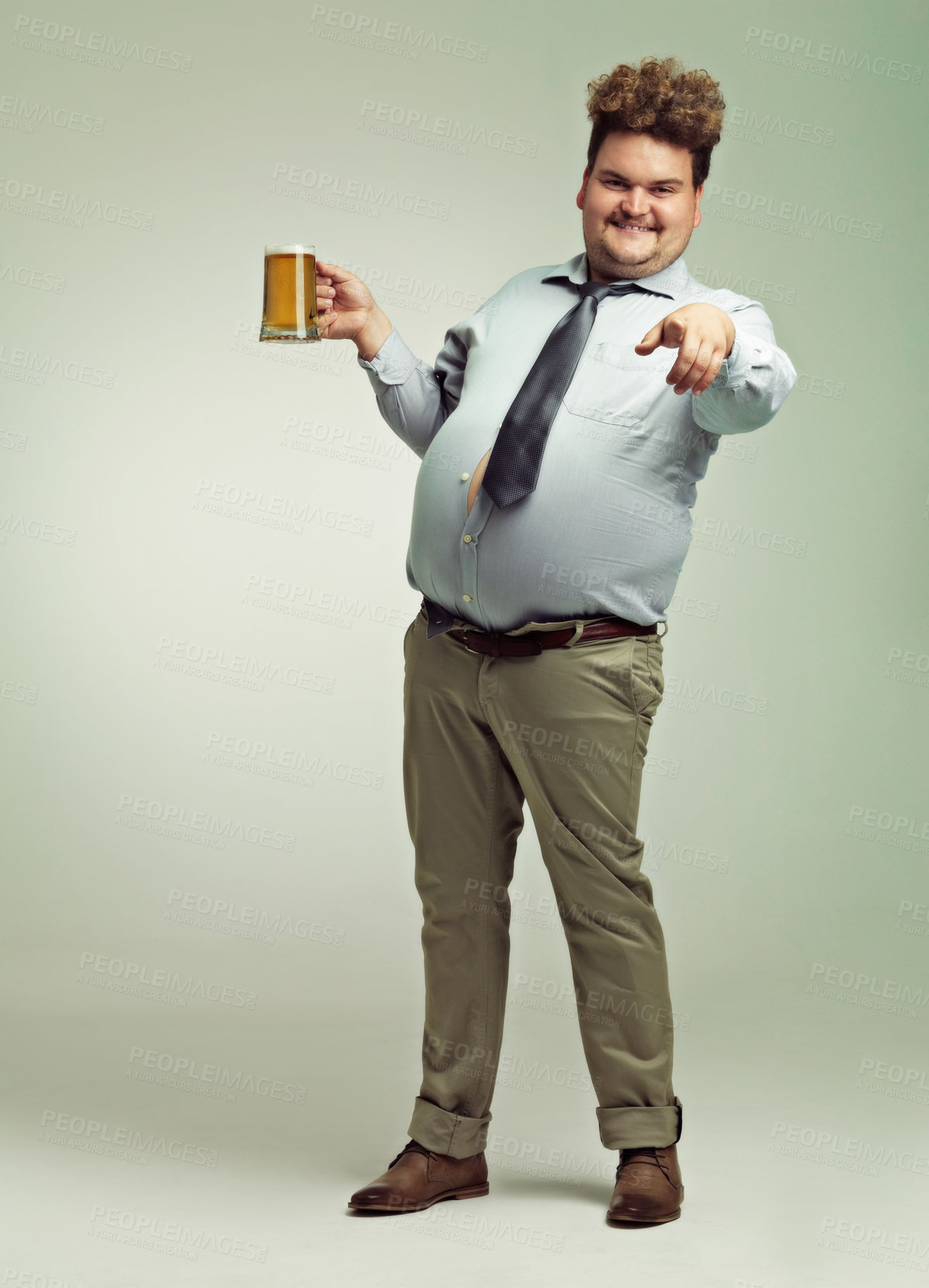 Buy stock photo Man, portrait and pointing to you with beer for celebration, drink or party on a studio background. Male person or plus size model with glass or mug for beverage, wine or drinking on mockup space