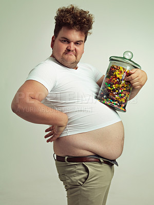 Buy stock photo Candy, jar and portrait of silly man in studio for snacks, sweets and dessert in container. Comic, goofy and overweight, isolated and plus size person with glass for unhealthy diet on background