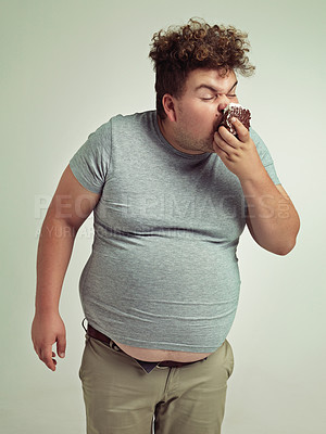 Buy stock photo Obesity, eating and man with cake in studio for unhealthy, sugar and sweet snack. Greedy, overweight and plus size person enjoying messy slice of chocolate dessert isolated by gray background