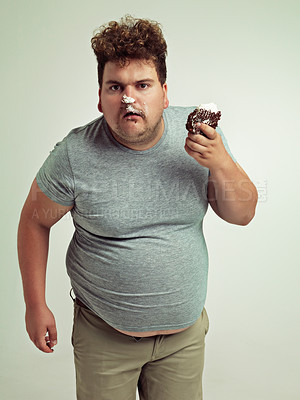 Buy stock photo Plus size, eating and portrait of man with cake in studio for unhealthy, sugar and sweet snack. Greedy, food and male person with messy slice of chocolate dessert isolated by gray background.