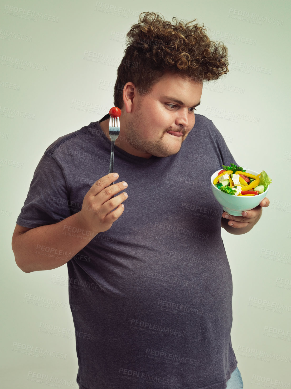 Buy stock photo Happy, plus size and man with salad in studio for healthy diet, natural nutrition and weight loss. Male person, organic food and tomato on fork with thinking for vitamin c, detox or vegan change