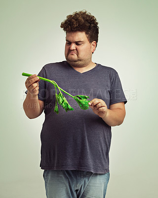Buy stock photo Plus size, diet and disgusted man with vegetable for health, nutrition and wellness in studio in white background. Weight loss, celery and unhappy male person for healthy food, wellbeing and detox