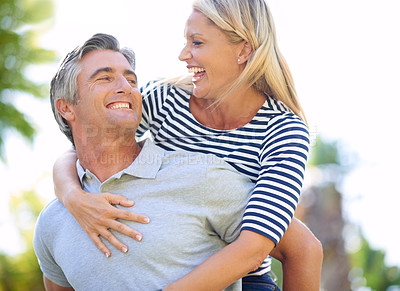 Buy stock photo Cropped shot of a handsome mature man piggybacking his wife in the park