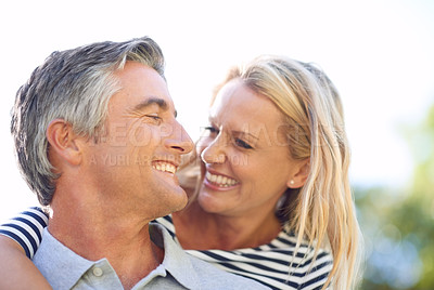 Buy stock photo Cropped shot of a handsome mature man piggybacking his wife in the park