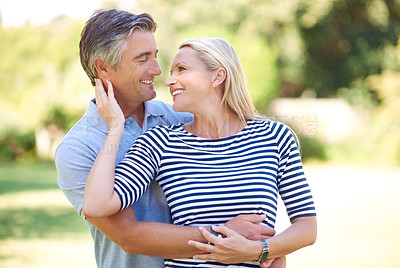 Buy stock photo Cropped shot of an affectionate mature couple standing face to face in the park