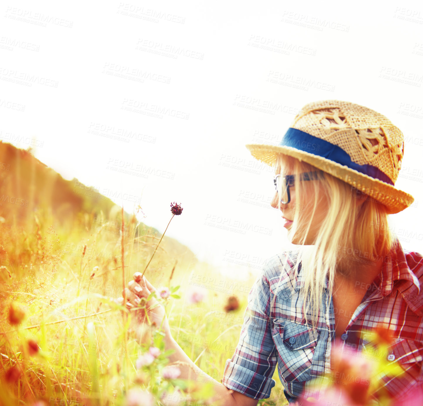 Buy stock photo Lens flare, countryside and hipster woman with flowers in field for freedom, wellness and fresh air outdoors. Nature, summer and female person in natural meadow for relax, calm and peace in morning
