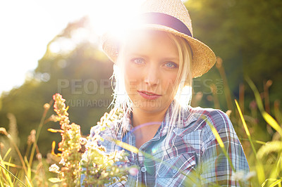 Buy stock photo Lens flare, countryside and portrait of woman with sun in field for freedom, wellness and relax. Nature, hipster and face of female person in flower meadow for sustainability and ecology in summer