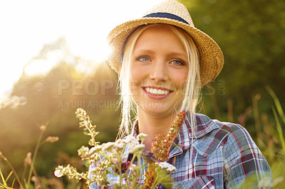 Buy stock photo Countryside, flowers and portrait of woman in field for sustainability, wellness and fresh air outdoors. Nature, summer and face of hipster person in meadow to relax, calm and peace with lens flare