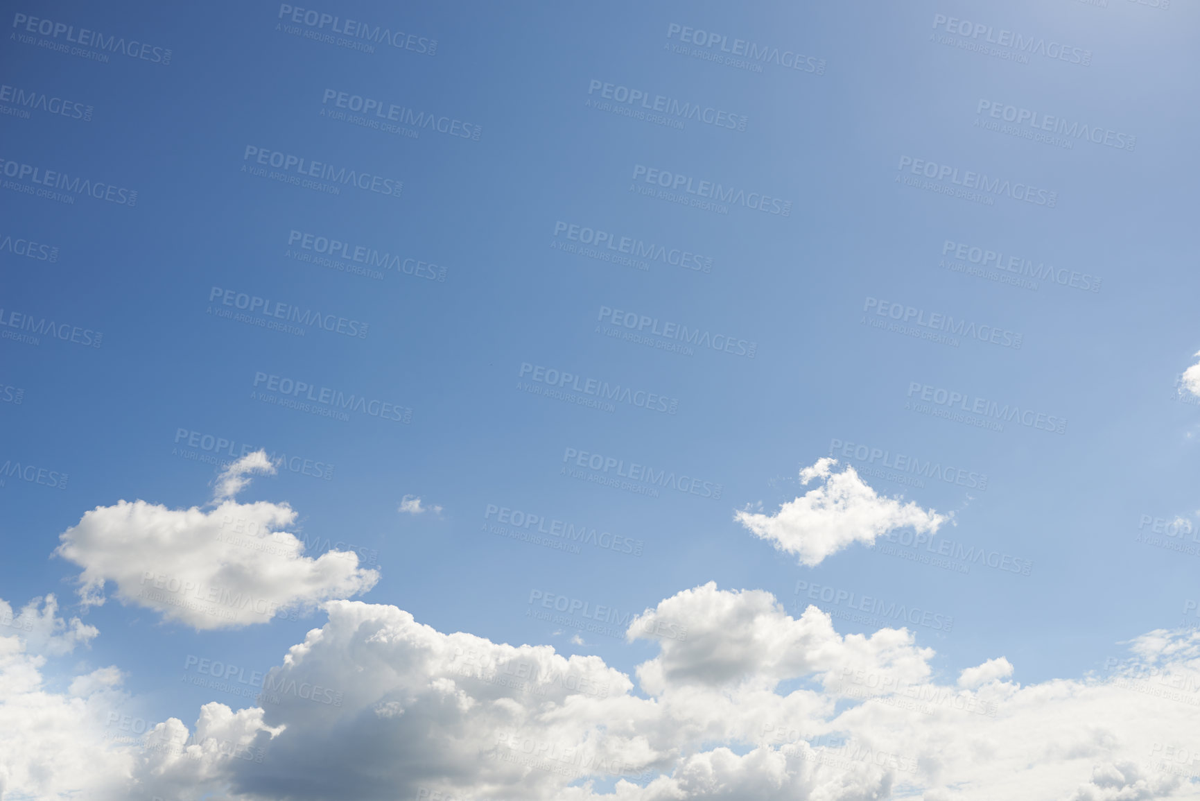 Buy stock photo Bright cloudy blue sky on a beautiful summer afternoon. Cloudscape and the sun shining on an overcast day with copy space. A vibrant horizon with sunlight and sunray flares with white cumulus clouds 
