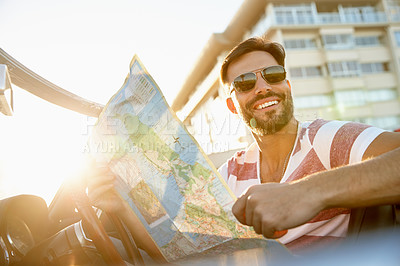 Buy stock photo Shot of a young man in his car looking at a map