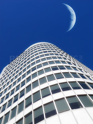 Buy stock photo Half a moon over a building skyscraper, shining in bright blue sky. Below the crescent of quarter moon over a tall modern structural architecture, foreboding doomed capitalism or an economical crisis