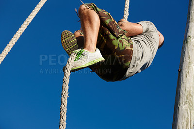 Buy stock photo Shot of a man climbing up a rope at bootcamp