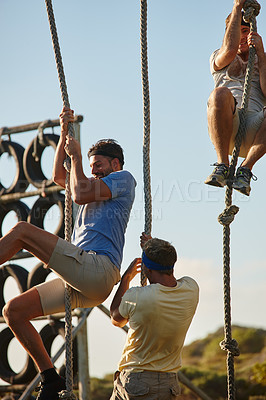 Buy stock photo Shot of a group of men going through an obstacle course at bootcamp