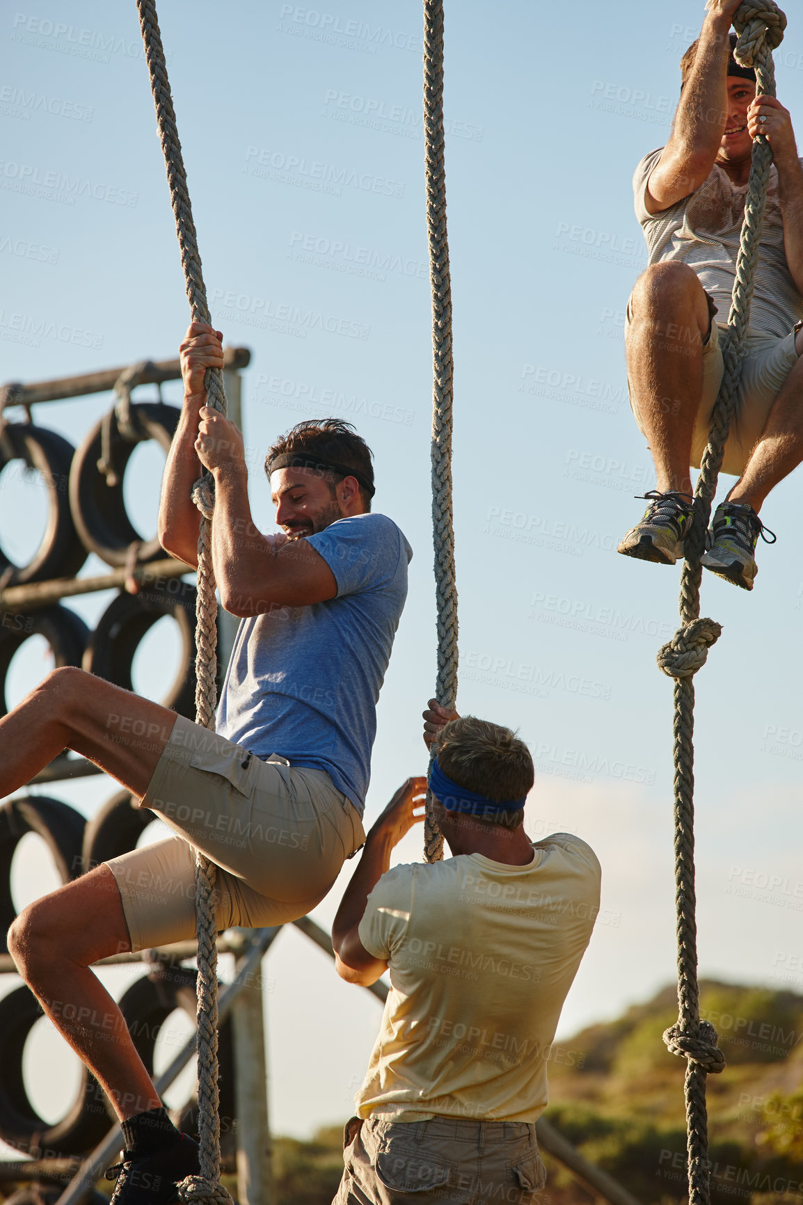 Buy stock photo Shot of a group of men going through an obstacle course at bootcamp