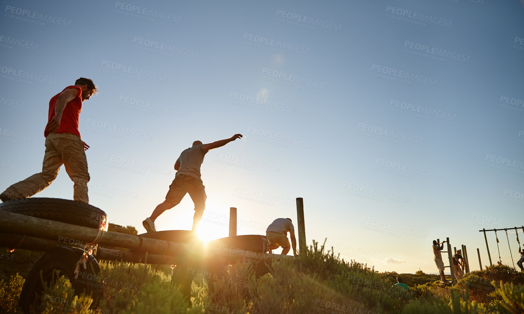 Buy stock photo Shot of a group of men going through an obstacle course at bootcamp