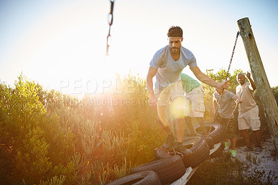 Buy stock photo Shot of a group of men going through an obstacle course at bootcamp