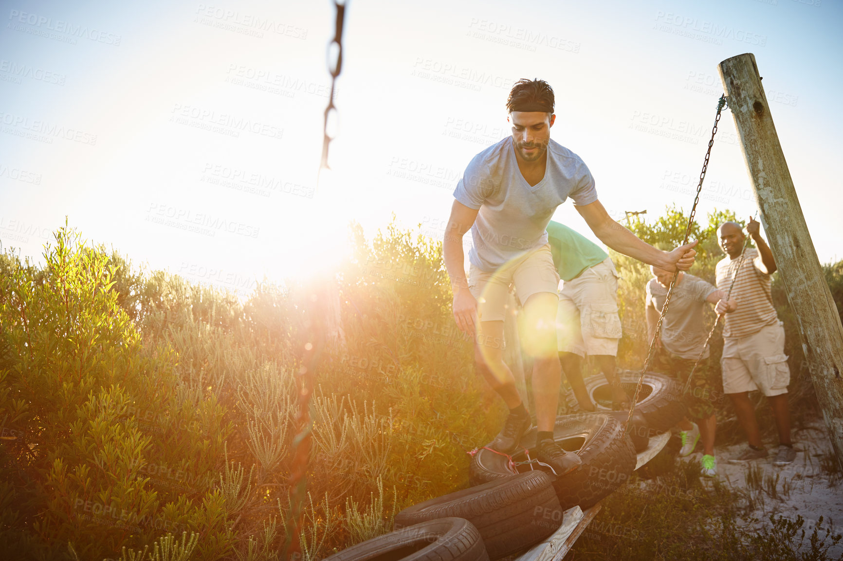 Buy stock photo Shot of a group of men going through an obstacle course at bootcamp