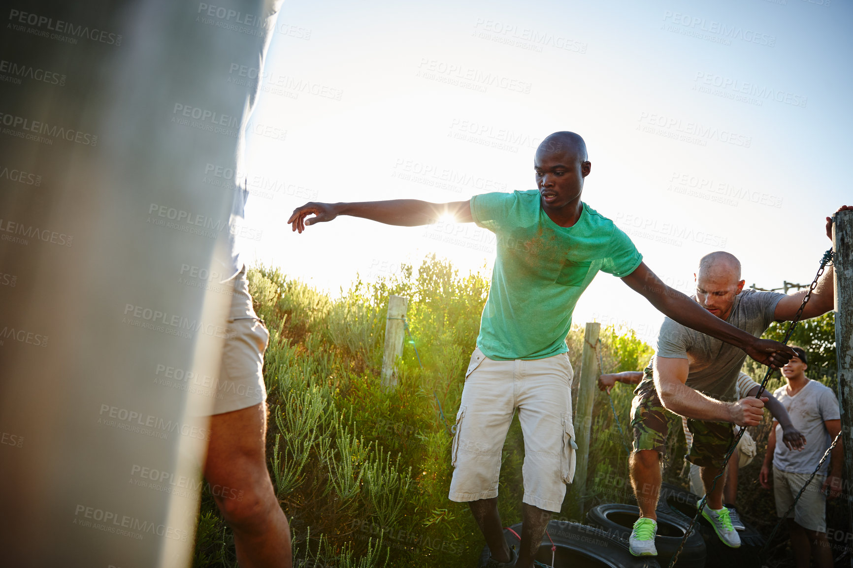 Buy stock photo Men, obstacle course and outdoor for balance, exercise and bootcamp tire beam for endurance. Friends, fitness and workout in nature for athlete, health or masculine strength for tough weekend bonding