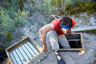 Buy stock photo Shot of a young man going through an obstacle course at bootcamp