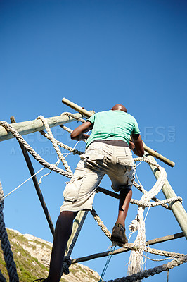 Buy stock photo Shot of a young man climbing over an obstacle at bootcamp