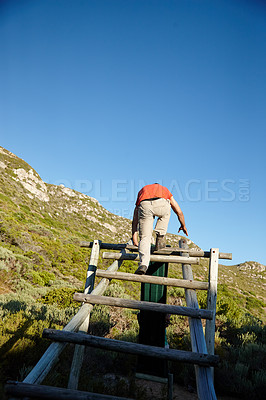 Buy stock photo Rearview shot of a man climbing over an obstacle at bootcamp