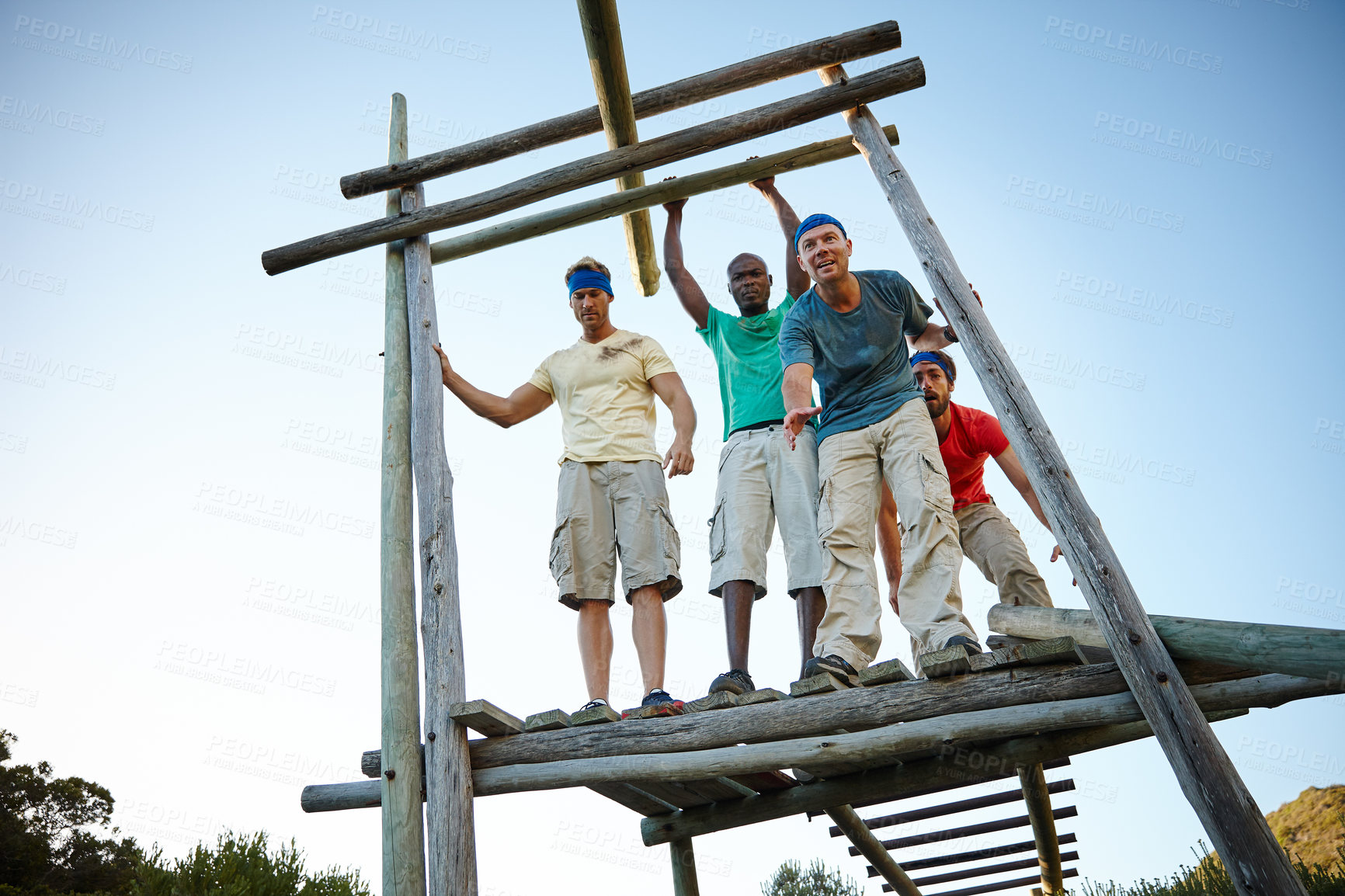 Buy stock photo Shot of a group of men going through an obstacle course at bootcamp