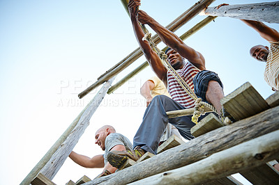 Buy stock photo Shot of a group of men going through an obstacle course at bootcamp