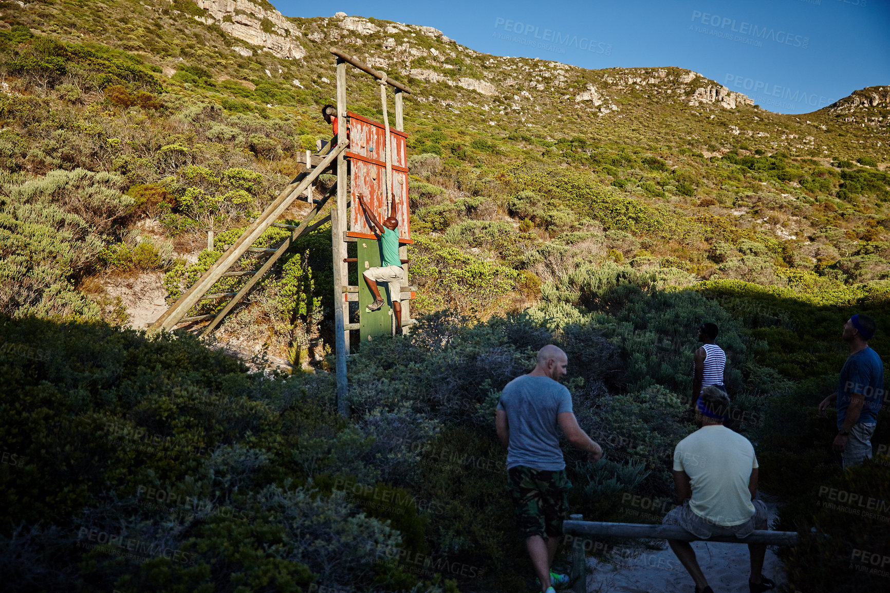 Buy stock photo Shot of a group of men going through an obstacle course at bootcamp