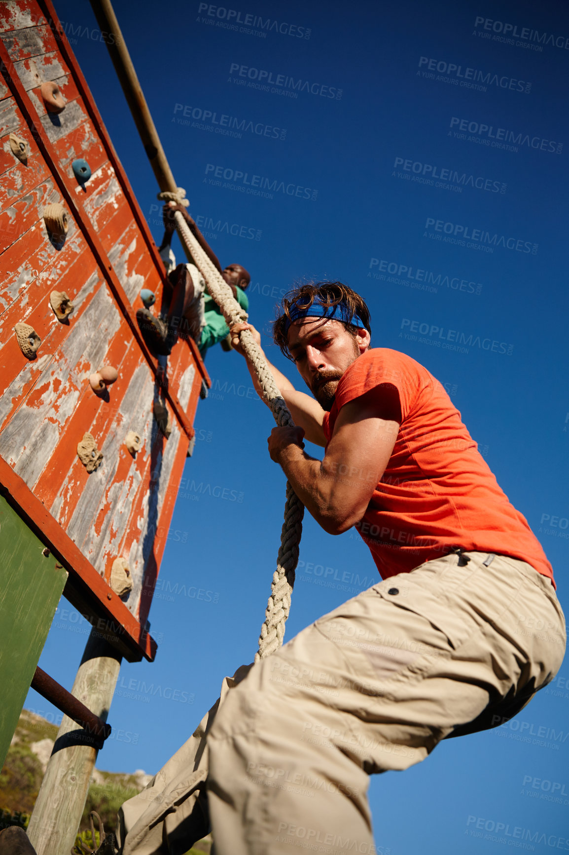 Buy stock photo Shot of a young man climbing over an obstacle at military bootcamp