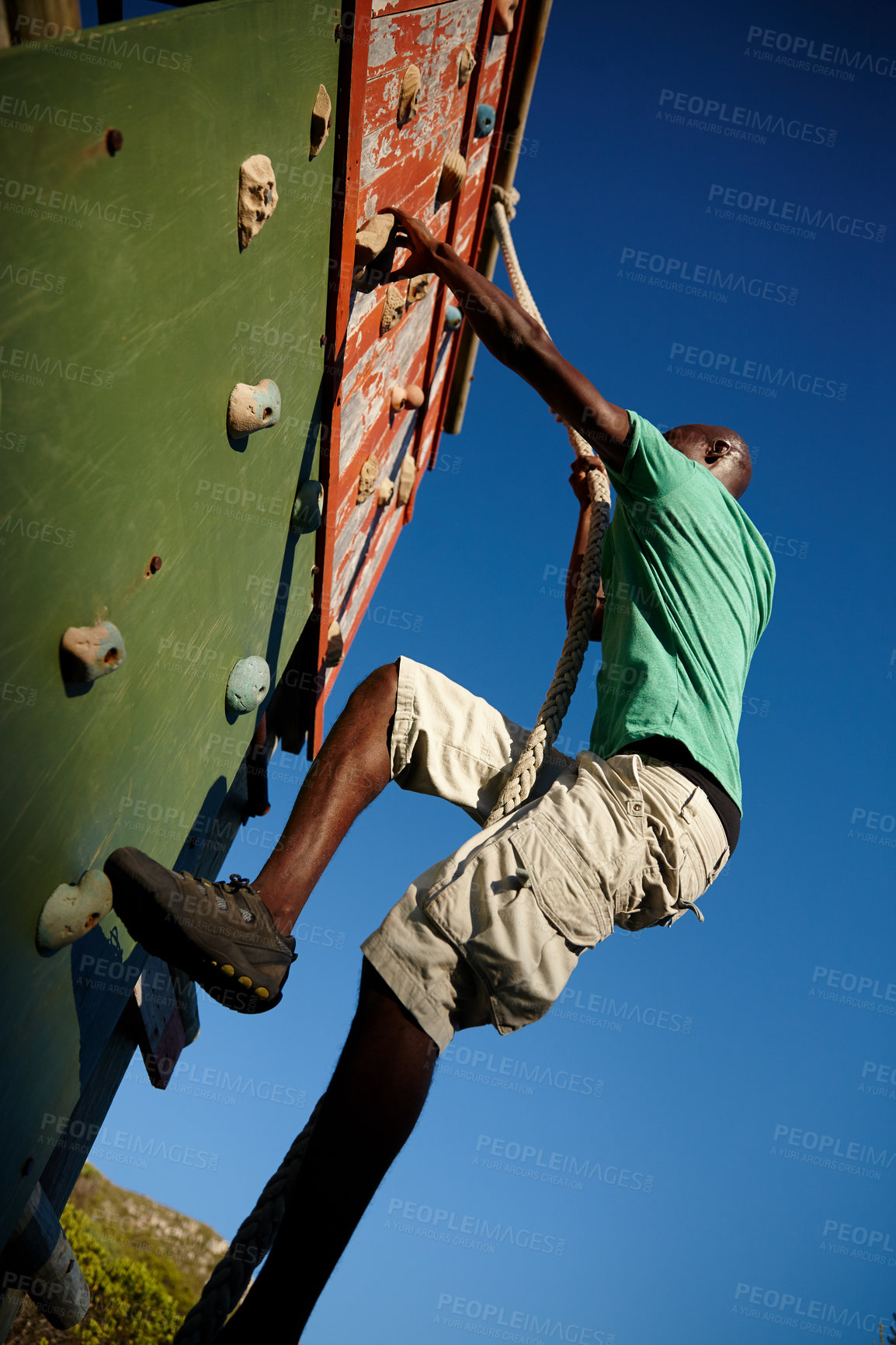 Buy stock photo Shot of a young man climbing over an obstacle at military bootcamp