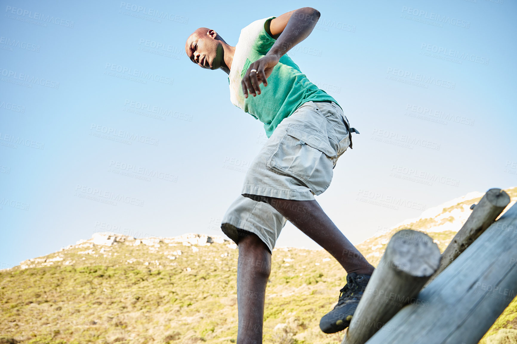 Buy stock photo Shot of a young man going over an obstacle at bootcamp