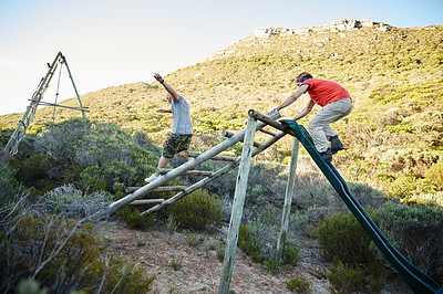 Buy stock photo Shot of young men going through an obstacle course at bootcamp