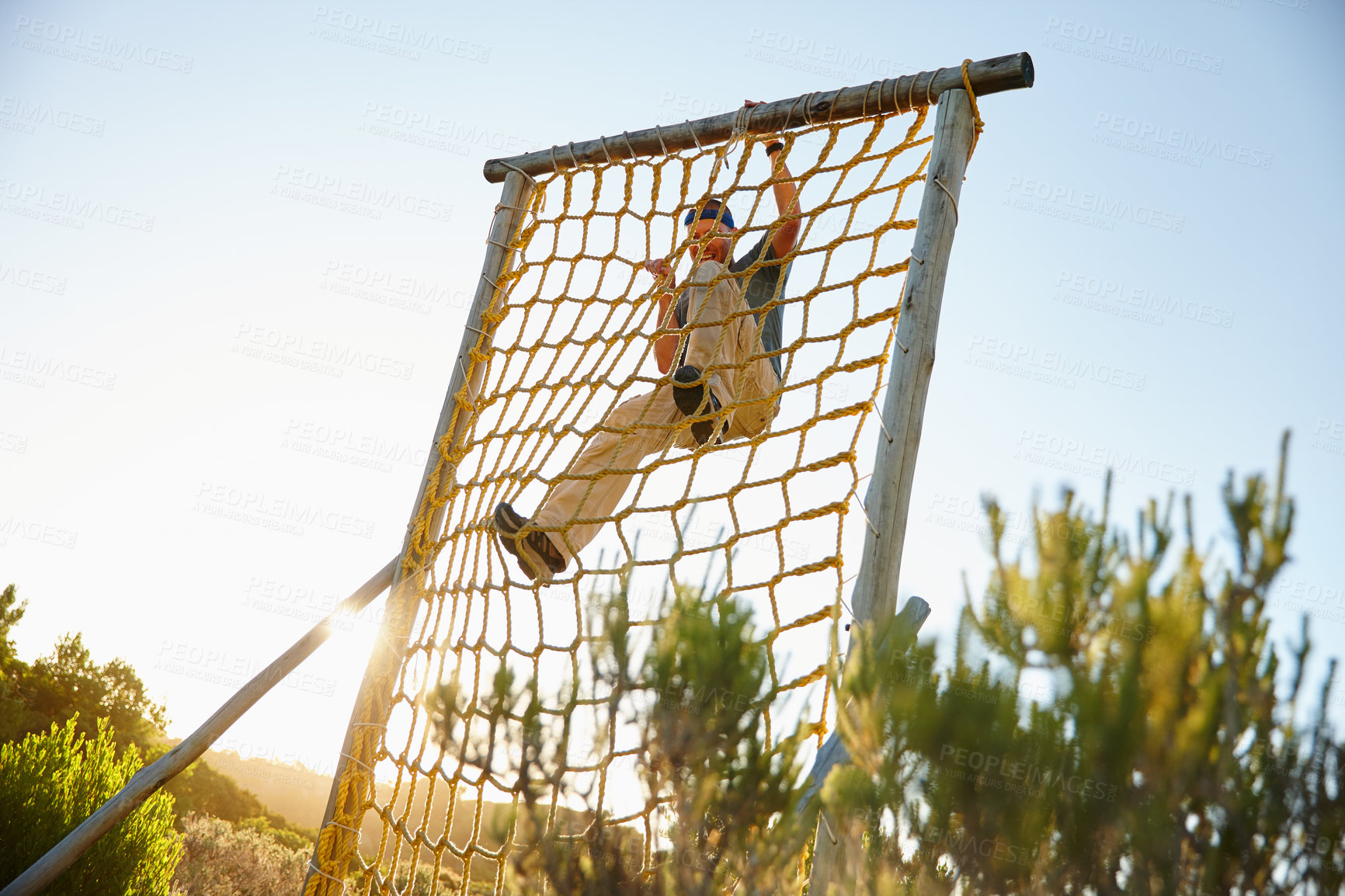 Buy stock photo Shot of a man climbing over an obstacle at bootcamp