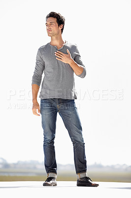 Buy stock photo Full length shot of a handsome young man standing on a rooftop