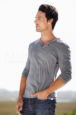 Buy stock photo Shot of a handsome young in casualwear standing outside