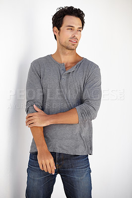 Buy stock photo Shot of a handsome young man posing against a white wall