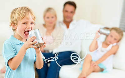 Buy stock photo Home, family and children with tin can, game and fun in a living room, love and bonding together. Parents on a sofa, mother and father with kids, apartment or communication with smile, playing or joy