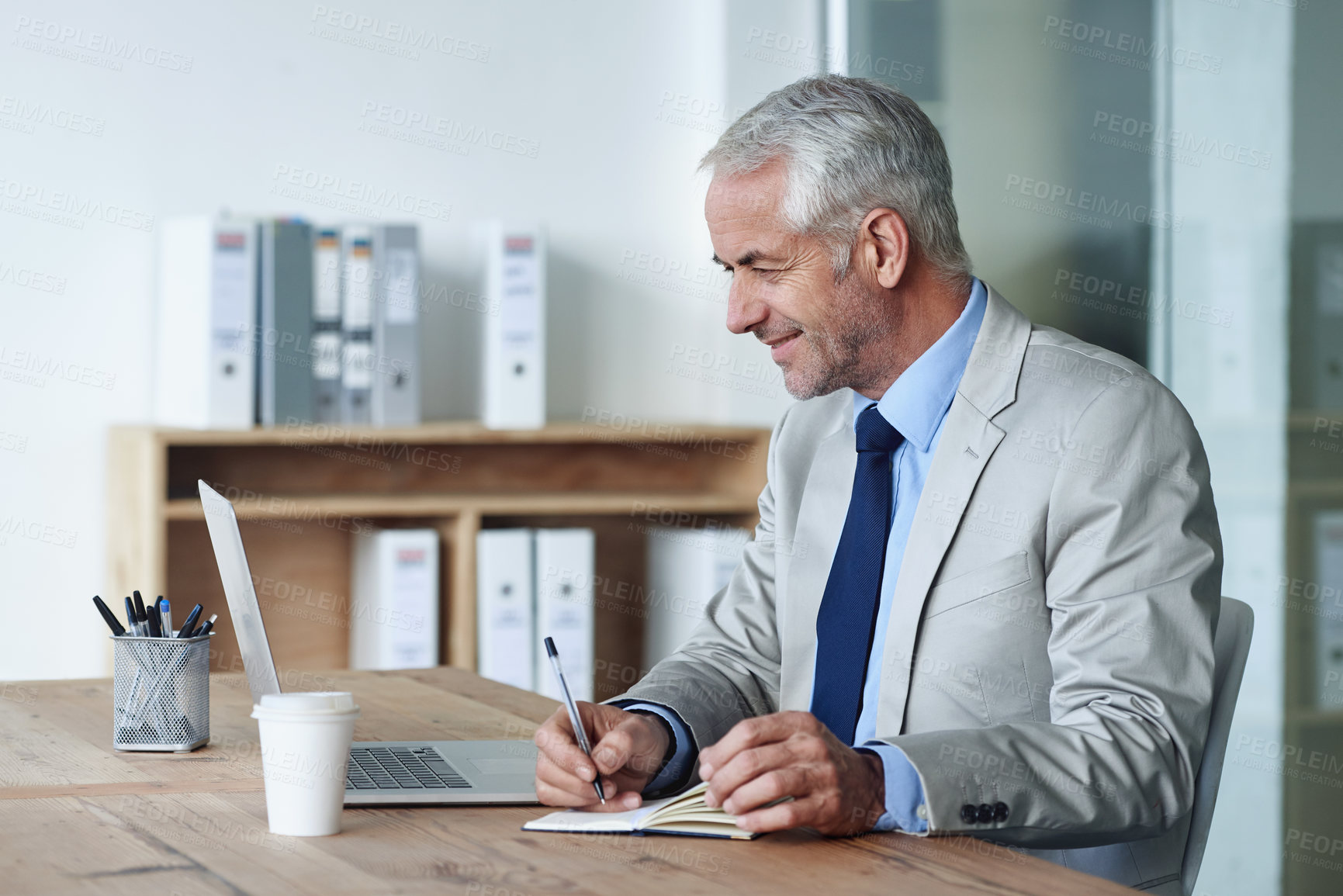 Buy stock photo Man, boss and notes while working on laptop, coffee and office for stakeholder budget account. Senior, manager and indoors for company, book and writing in diary at desk preparing for meeting